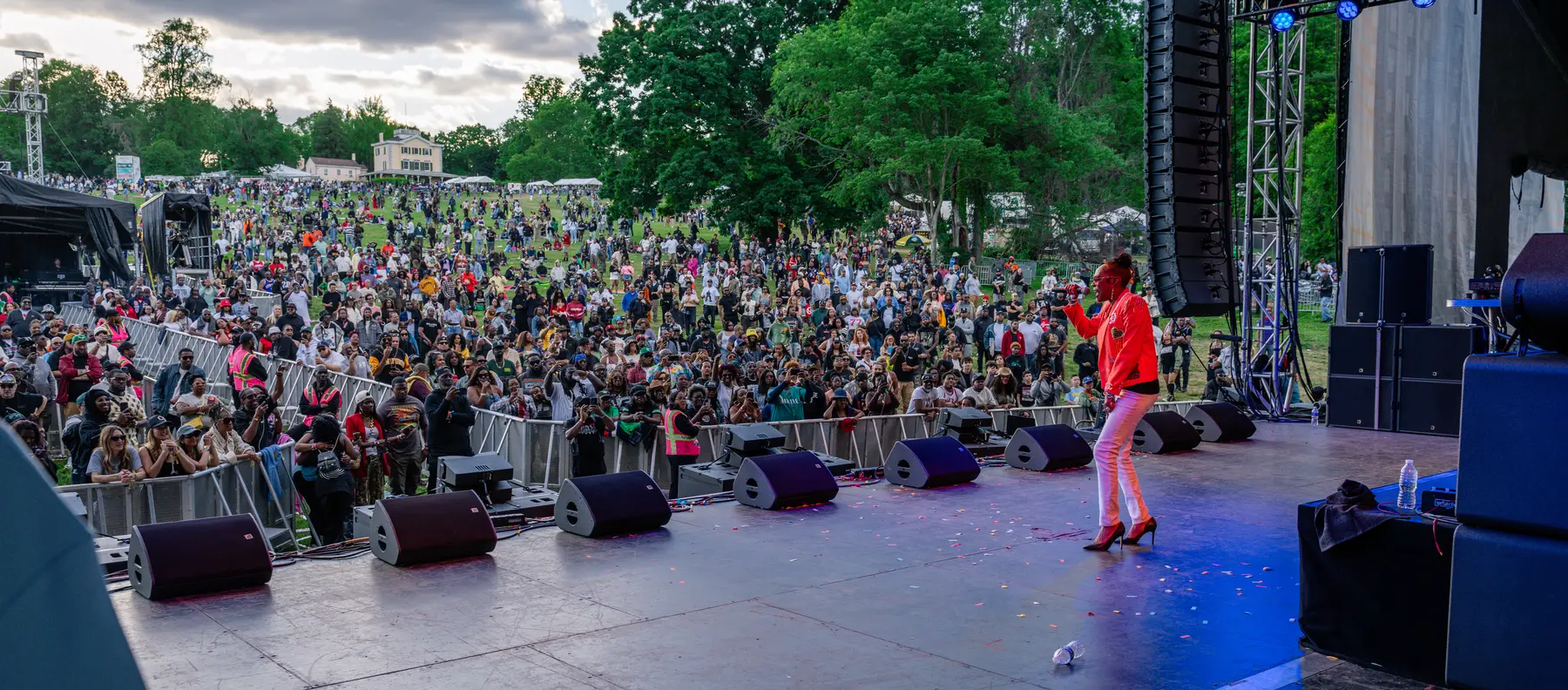 Malika Love on the main stage at the 2026 Roots Picnic, facing a crowd that runs back to the trees
