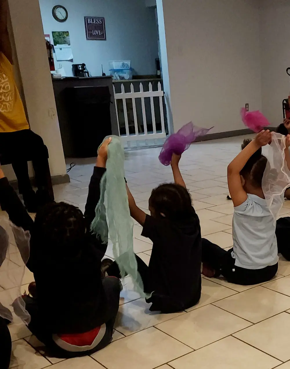 Children at a Hip Hop Storytime, sitting in a circle with scarves raised