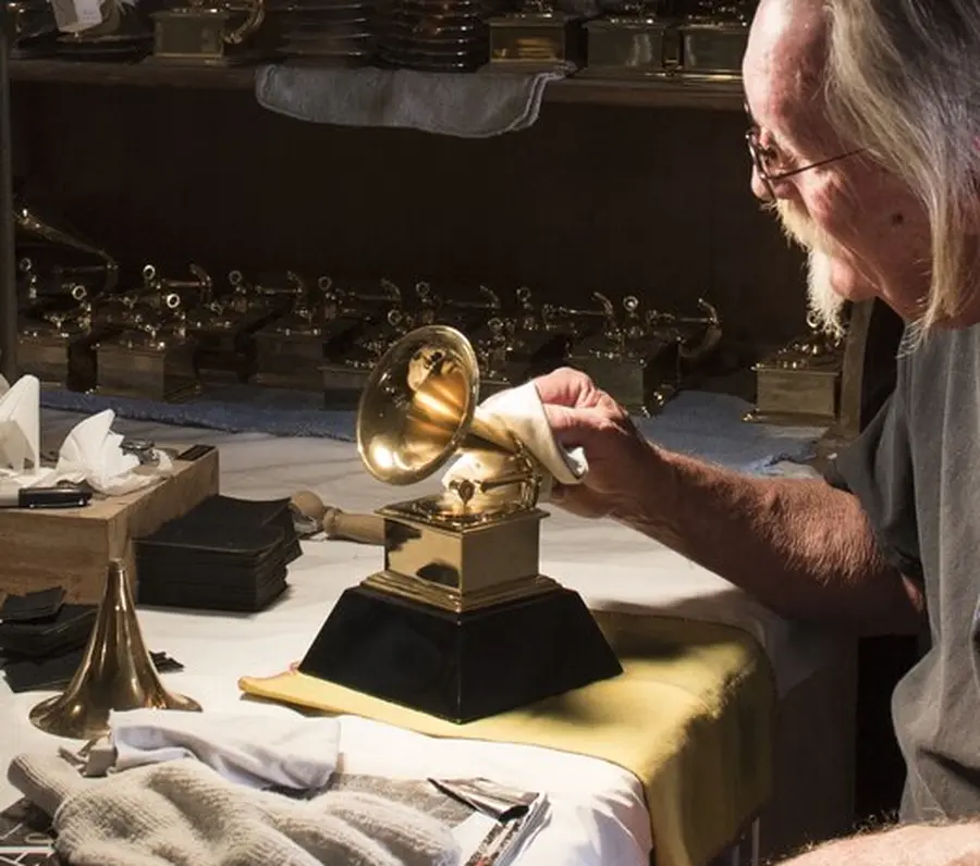 A gold-plated Grammy trophy being polished by hand in the workshop that makes them